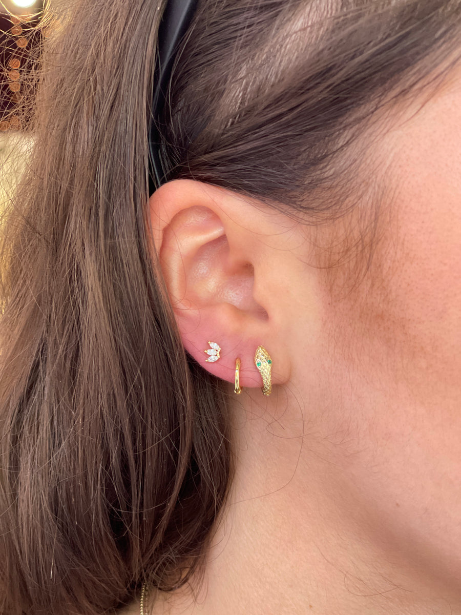 Earring stack on white model with snake Huggie, simple Huggie, and stud