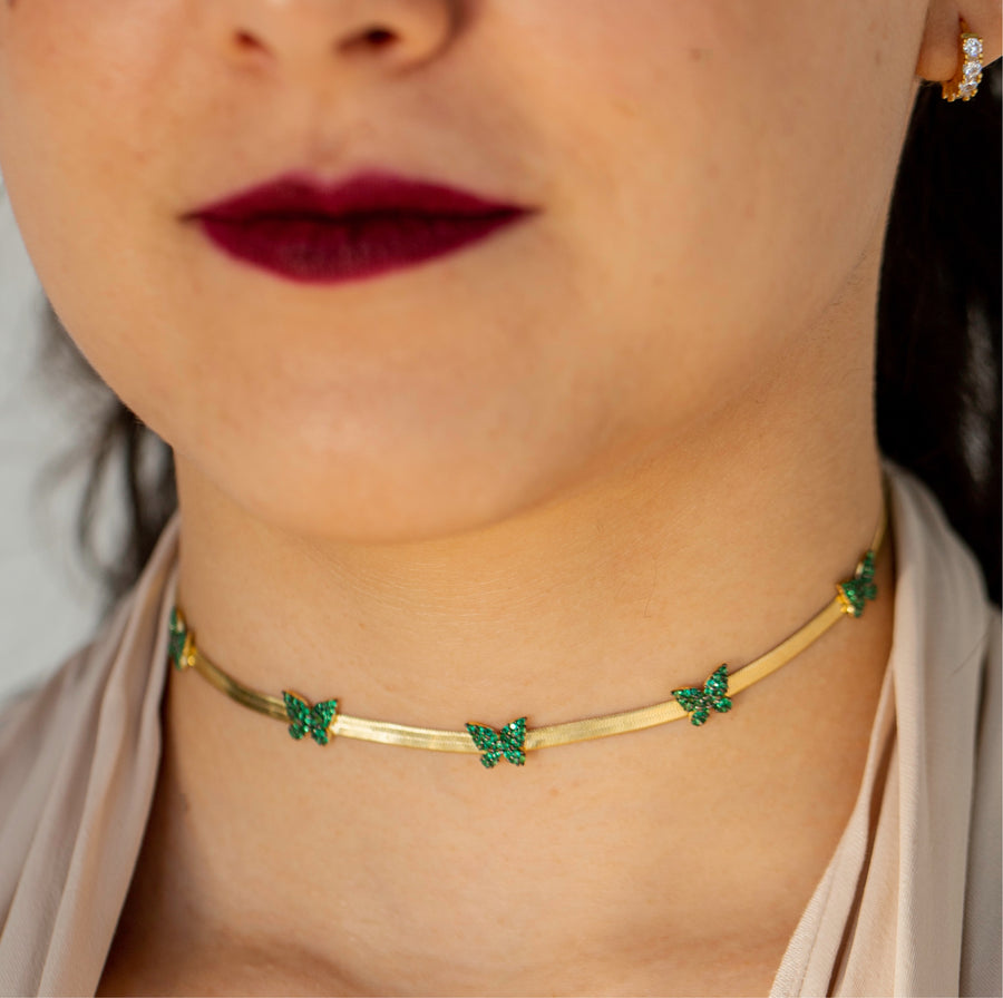 Model wearing Herring Bone choker with green pave butterflies